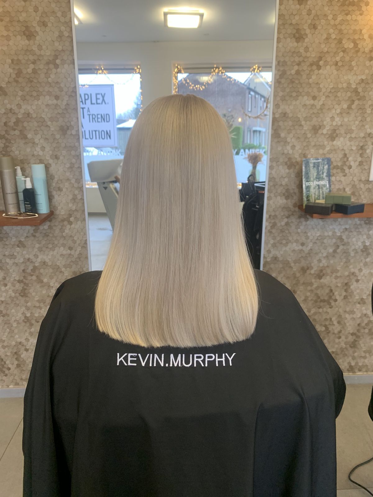 Lang, glad en koel blond haar, van achteren gezien in de salon