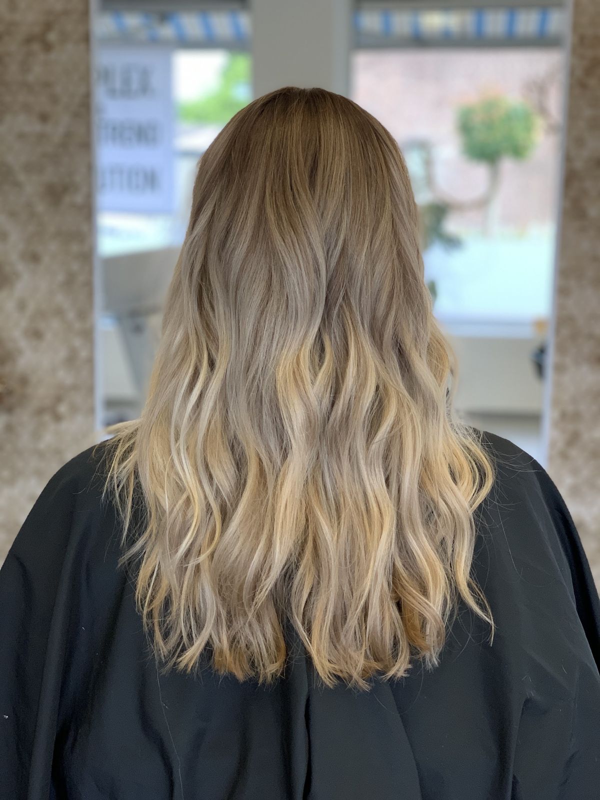 Lang blond haar met zachte slag, van achteren gezien